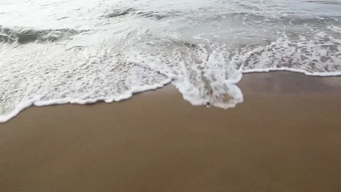 Sea waves with foam run to an empty sandy beach Stock Footage 153998500