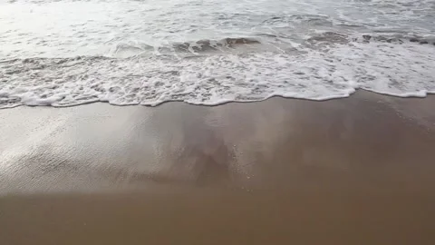 Sea waves with foam run to an empty sandy beach towards you Stock Footage 153998501