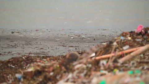 Sea waves full of litter hitting the beach. Huge dump in tropical paradise. M Stock Footage 127393521