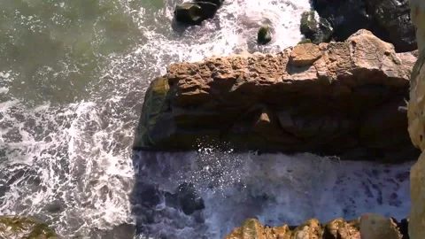Sea waves hit a large rock with force, video taken from above Stock Footage 142399108