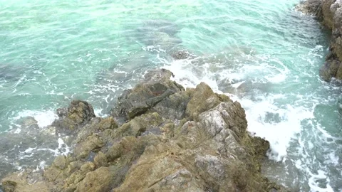 The sea waves hit the rocks, causing a splash of water. Stock Footage 152546753