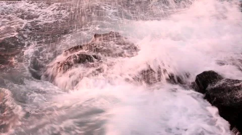 Sea waves hit the rocks at sunset Видео 617952