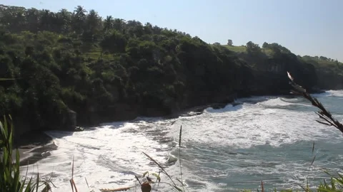 Sea waves hit the sea stack and create sea foam Stock Footage 294851949