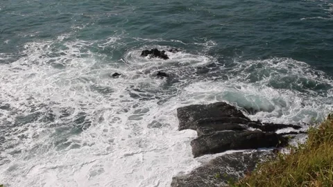Sea waves hit the sea stack and create sea foam Stock Footage 294851969