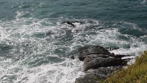 Sea waves hit the sea stack and create sea foam Stock Footage 294851996