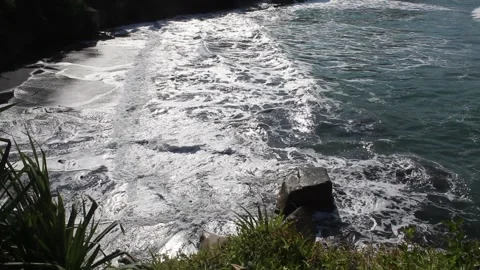 Sea waves hit the sea stack and create sea foam Stock Footage 294852046