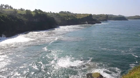 Sea waves hit the sea stack and create sea foam Stock Footage 294852131
