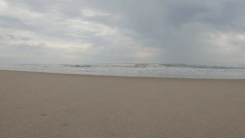 Sea waves hits the sandy shore on cloudy day Stock Footage 121837810