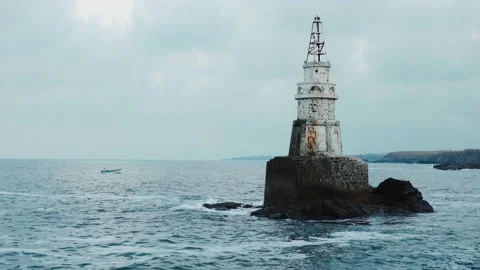 Sea waves hitting and splashing against old white lighthouse Stock Footage 158151906
