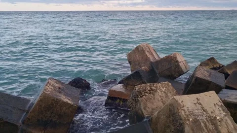 Sea Waves Hitting Concrete Blocks at Sunset Stock Footage 319817790