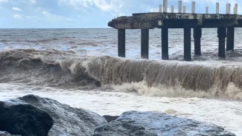 Sea waves hitting pier wide shot along a rocky coast Stock Footage 345361674