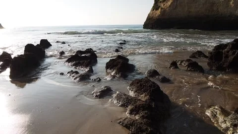 Sea waves hitting the rocks on the sand at low tide. Vídeos de archivo 260263945