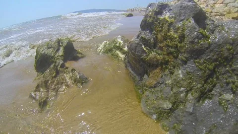 Sea waves hitting the some beach's rocks Stock Footage 104306226