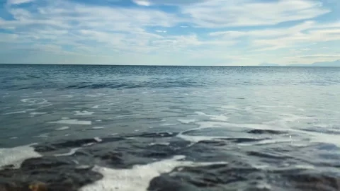 Sea waves lap along the beach and reflect the subtle shades of the sunset. Stock Footage 267578080