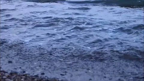 Sea waves lapping against the ashore, blue filter Stock Footage 77862863