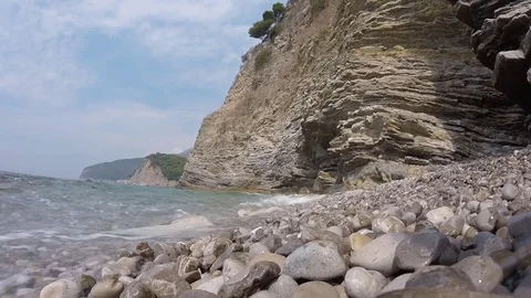 Sea waves lapping on the pebble beach. rocky shore and gentle sea wave video Stock Footage 82262531