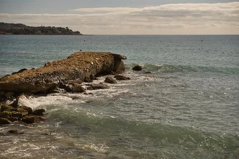 Sea waves lash line impact rock on the beach, located in Alicante Stock Photos