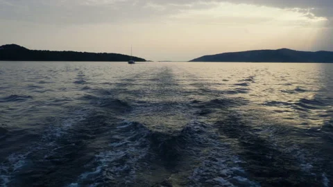 Sea waves left behind by a moving ship against the background of sunset Stockbeeldmateriaal 162540471