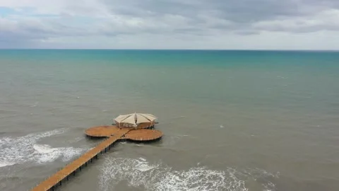 Sea waves reaching sandy beach. Pierce in the middle of Meditteranean Stock Footage 133460917