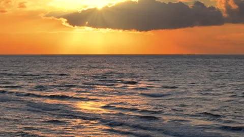 Sea waves with reflection of gold sunlight on the orange background. Stock Footage 248851163