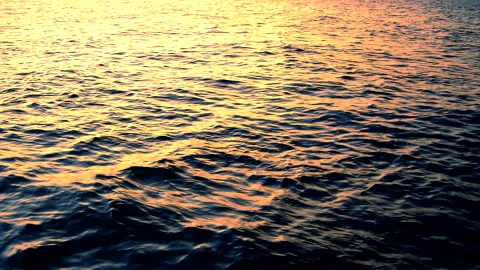 Sea waves with reflection of gold sunset light, by the beach, slow motion. 库存影片 243838674