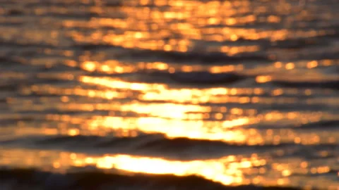 Sea waves with reflection of gold sunset light, by the beach. Stock Footage 243899636