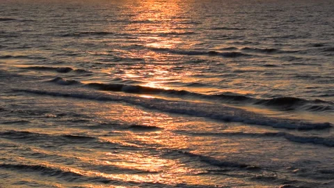 Sea waves with reflection of gold sunset light, by the beach, slow motion. Stock Footage 248850631