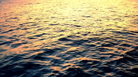 Sea waves with reflection of gold sunset light, by the beach, slow motion. Stock Footage 248851042
