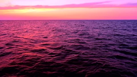 Sea waves with reflection of pink sunset light on the sunset sky background. Stock Footage 239014140