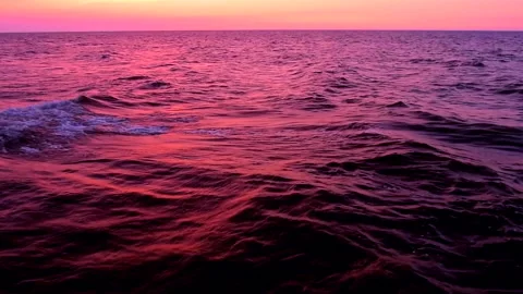 Sea waves with reflection of pink sunset light on the purple background. Stock Footage 239427655
