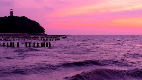 Sea waves with reflection of pink sunset light on the purple background. Stock Footage 239428867