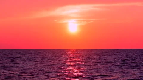 Sea waves with reflection of red sunset light on the red sunset sky background. Stock Footage 239012103