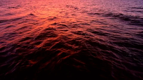 Sea waves with reflection of red sunset light, by the beach, slow motion. Stock Footage 239436772