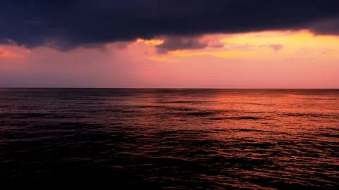 Sea waves with reflection of red sunset on the purple sunset background. Stock Footage 240985039
