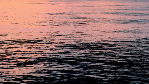 Sea waves with reflection of red sunset light, by the beach, slow motion. 库存影片 240985434