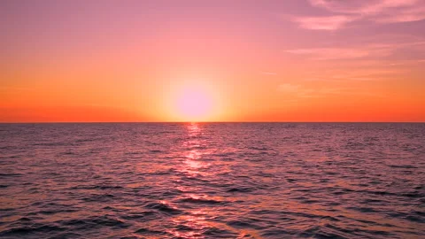 Sea waves with reflection of red sunset light on colorful sky. ProRes 422 HQ. 库存影片 247919934