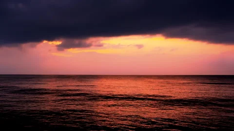 Sea waves with reflection of red sunset on the purple sunset. ProRes 422 HQ. 库存影片 247920503