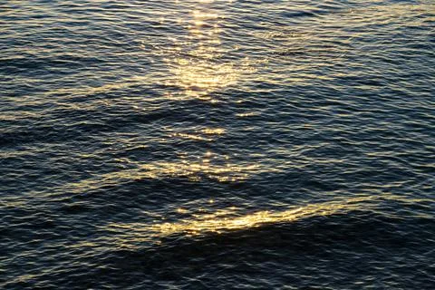 Sea waves, reflection of sunlight from the surface of the water during sunset Stock Photos