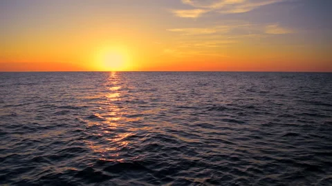Sea waves with reflection of yellow sunlight on orange background. Stock Footage 243645191