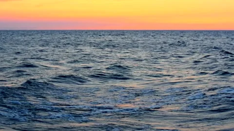 Sea waves with reflection of yellow sunset light. 库存影片 248851335