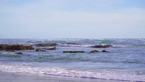 Sea waves, rocks and sandy beach on sunny afternoon. 動画素材 109480055