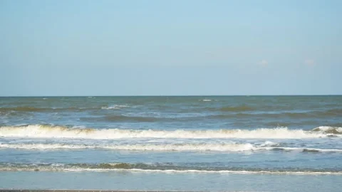 Sea waves roll and splash into the shore, Green wave breaking with blue sky Stock Footage 132231777