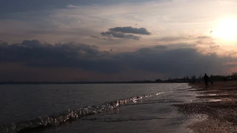 Sea waves roll ashore at sunset Stock Footage 125666543