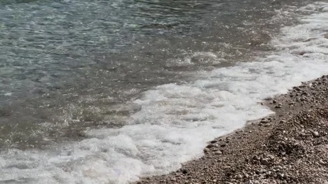 Sea waves roll beautifully onto the pebble shoreline Stock Footage 286897559