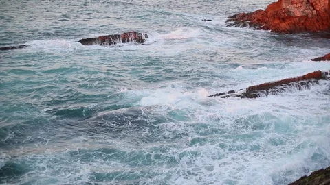 Sea waves roll on the brown pitfalls of the coast Stock Footage 130022468