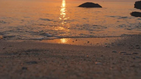 Sea waves roll on sandy beach. Sunset shines on water surface with yellow and Video stock 99003146