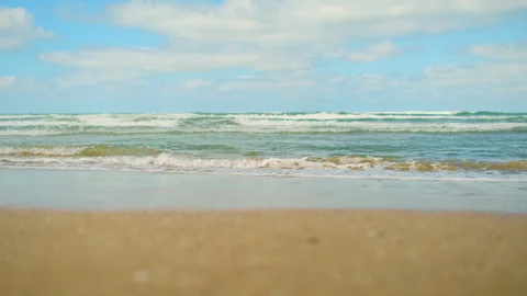 Sea waves roll on sandy shore in rhythmic motion Stock Footage 309551328