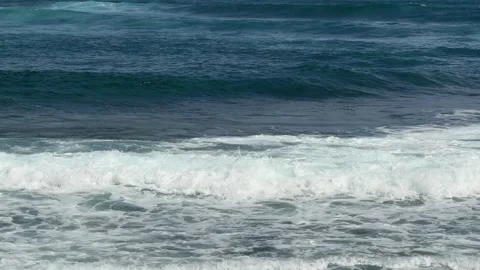 Sea waves roll in sequence toward a rocky coastline, forming repeating water 库存影片 329277723