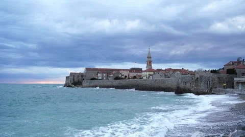 Sea waves roll on the shore of the old town of Budva near the fortress wall Stock-Footage 268886416