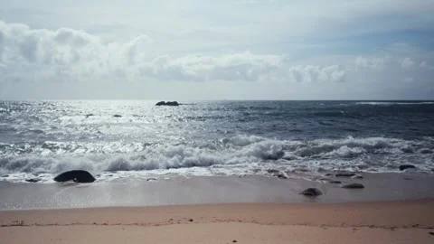 Sea waves rolling on a empty beach with blue sky over horizon. Stock Footage 304101326